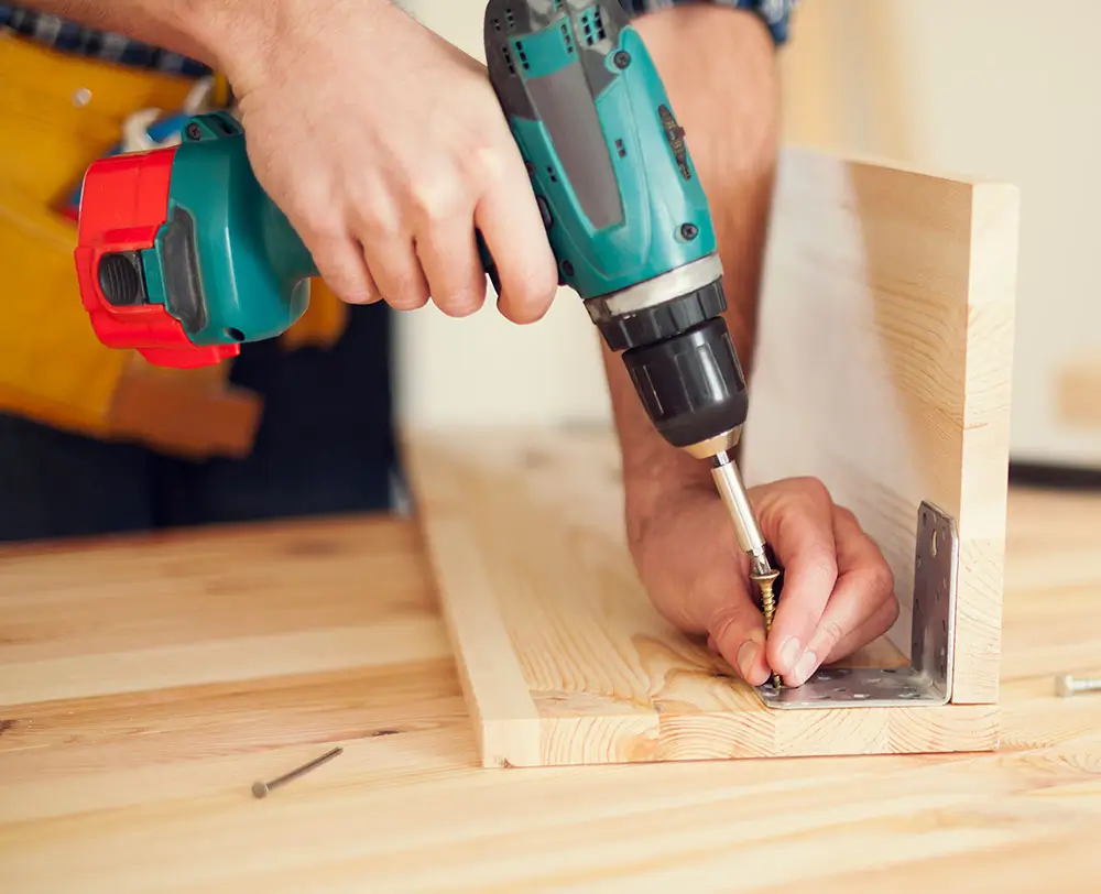 Buildnest handyman using a handheld power drill during a home repair task in Welland, Niagara Region. Skilled in drilling, carpentry, and general handyman services for household improvements.