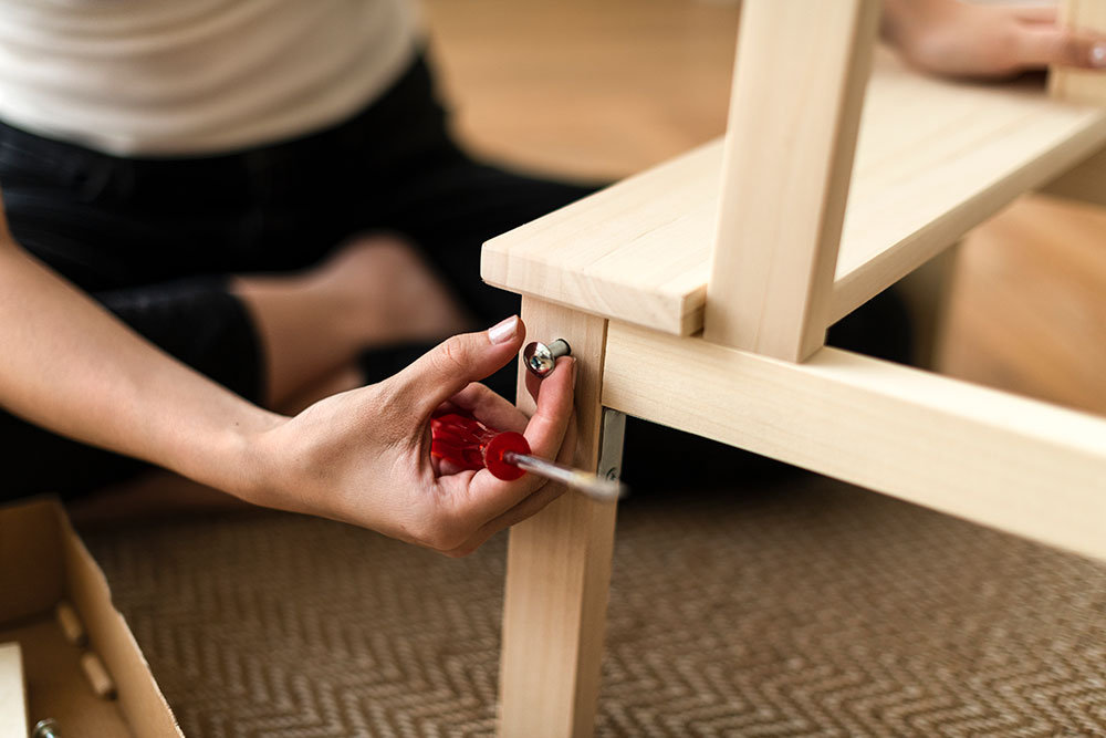 Buildnest handyman assembling a wooden chair for home furniture setup in Niagara Region — delivering reliable indoor handyman and furniture assembly services.