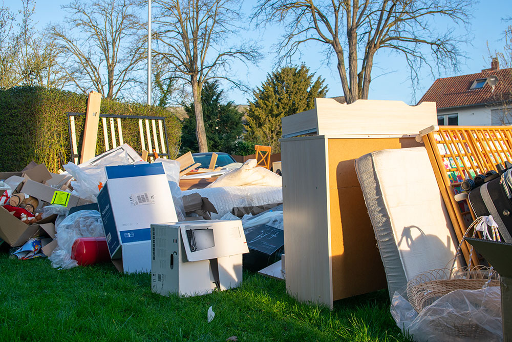 Cardboard boxes and packaging waste in backyard garden – Buildnest’s yard cleanup and post-service waste removal in Niagara Region