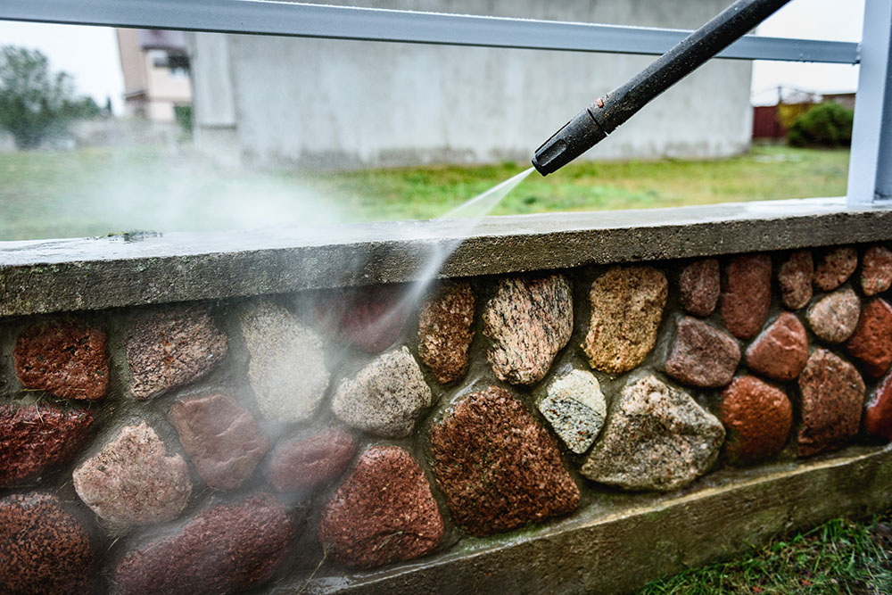 Buildnest technician cleaning wall sludge using pressurized water – expert pressure washing and exterior surface cleaning in Niagara Region